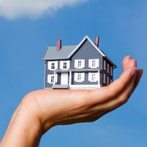 a persons hand holding a house